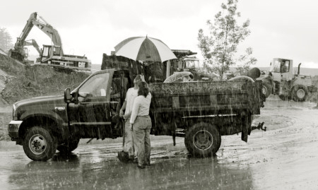 couple next to dump truck in the rain